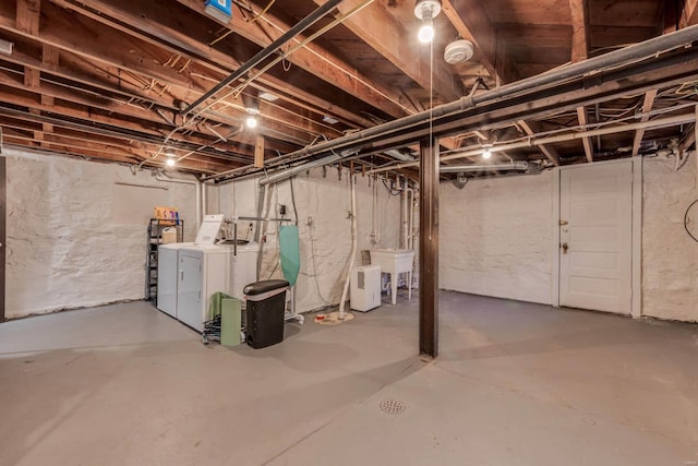 unfinished basement with independent washer and dryer and a sink