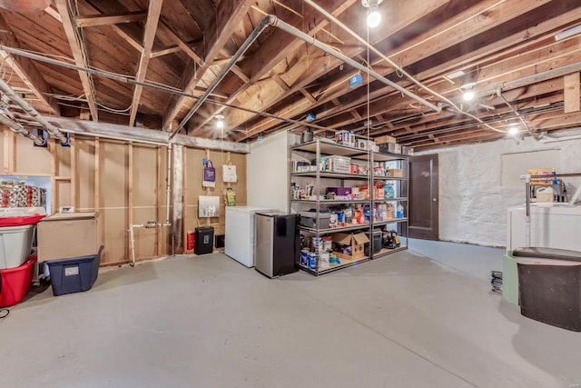 unfinished below grade area with refrigerator and washing machine and clothes dryer