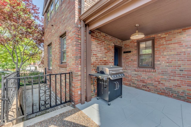 view of patio with area for grilling, fence, and a gate