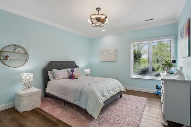 bedroom featuring crown molding, light wood-style floors, visible vents, and baseboards