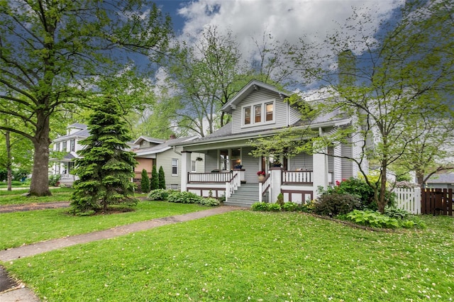 bungalow featuring fence, a porch, and a front yard