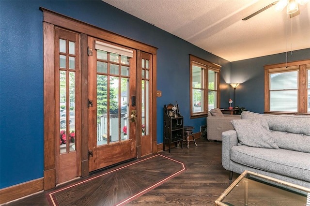 interior space featuring baseboards, ceiling fan, a textured ceiling, and wood finished floors