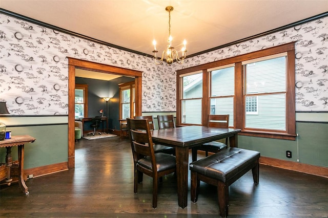 dining room with crown molding, wainscoting, dark wood-style floors, an inviting chandelier, and wallpapered walls