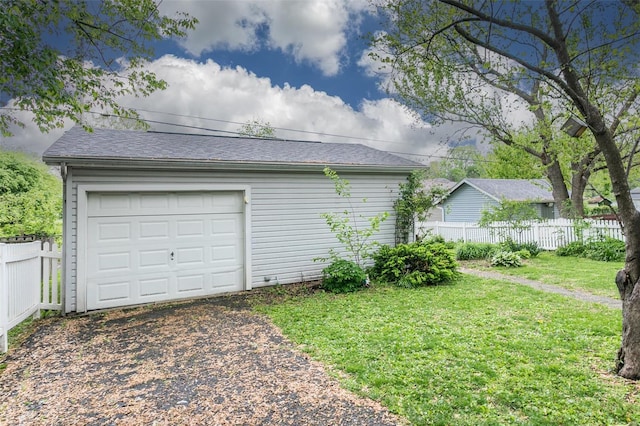 detached garage with fence and driveway