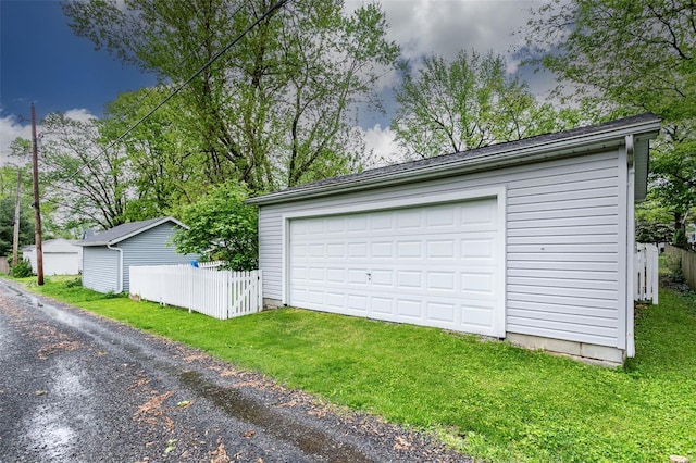 detached garage featuring fence