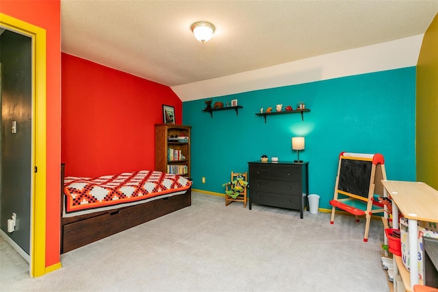 carpeted bedroom featuring baseboards and vaulted ceiling