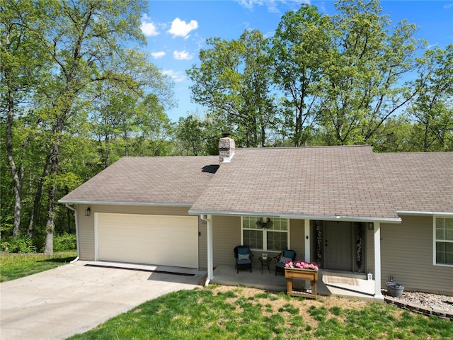 view of front of home featuring an attached garage, a chimney, a shingled roof, a porch, and driveway