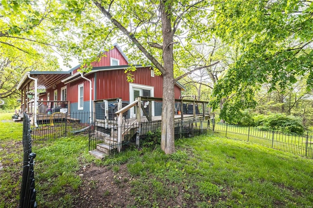 back of property with a yard and fence