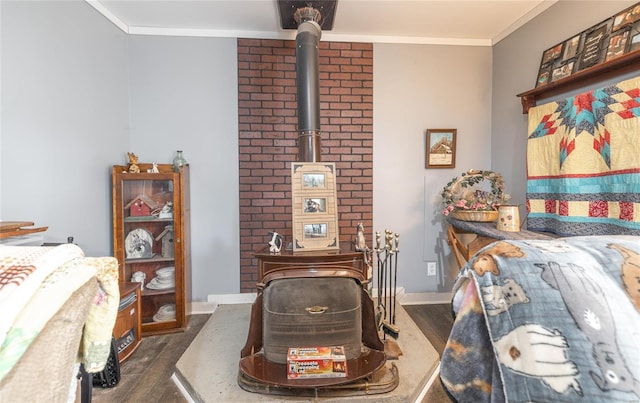 bedroom featuring a wood stove, crown molding, dark wood-style flooring, and baseboards