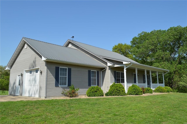 view of front of property featuring a garage, a porch, a front yard, concrete driveway, and metal roof