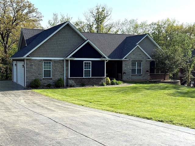 view of front of property featuring a garage, stone siding, driveway, and a front yard
