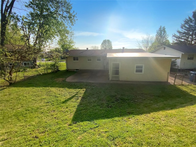 rear view of house with a lawn, fence, and a patio area
