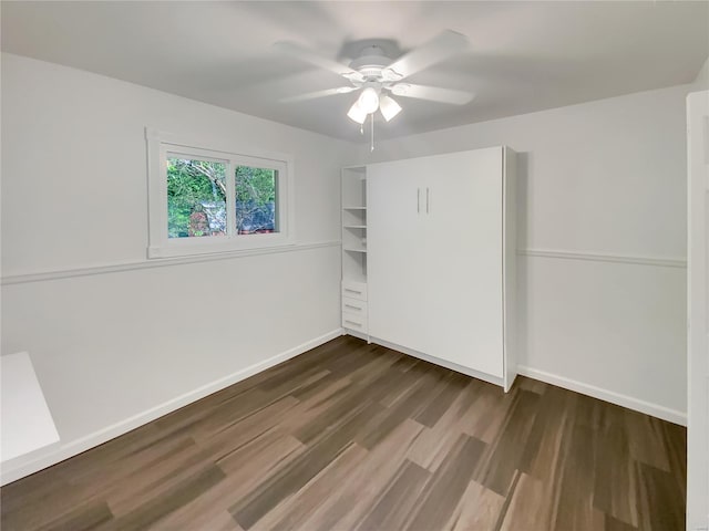 unfurnished bedroom featuring a ceiling fan, baseboards, and dark wood finished floors
