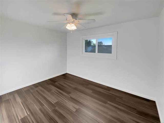 empty room featuring ceiling fan, dark wood-style floors, and baseboards