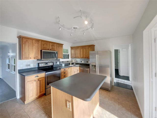kitchen with a kitchen island, backsplash, dark countertops, appliances with stainless steel finishes, and light tile patterned flooring
