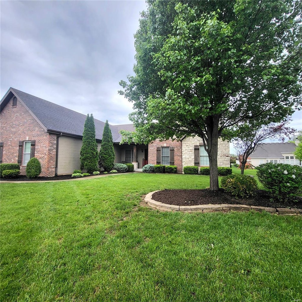 single story home featuring brick siding and a front yard