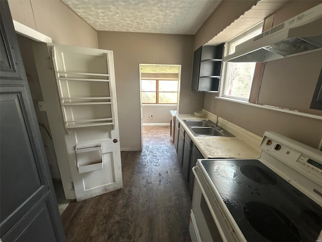 kitchen with a sink, dark wood-style flooring, baseboards, under cabinet range hood, and electric stove