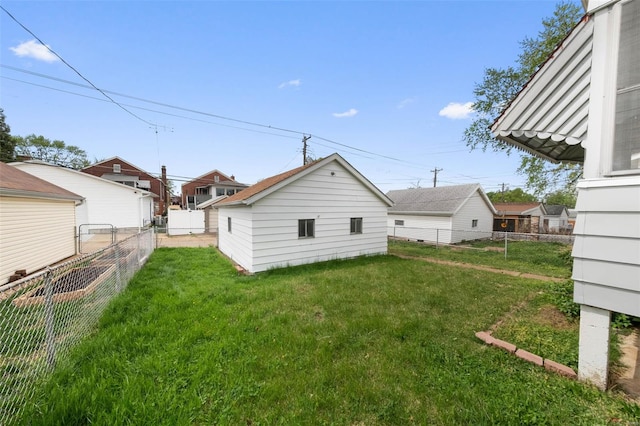 rear view of house with a lawn and a fenced backyard