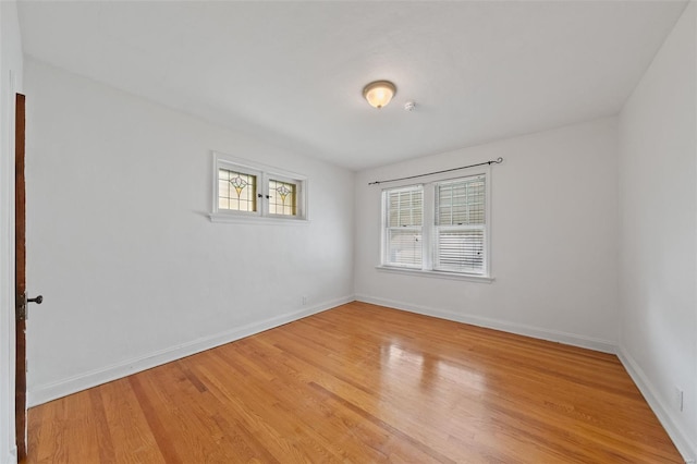 empty room featuring baseboards and light wood-style floors