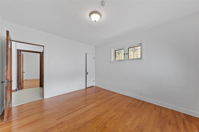 unfurnished bedroom with baseboards and light wood-type flooring