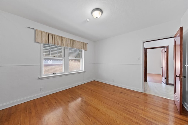 empty room featuring light wood-style floors and baseboards