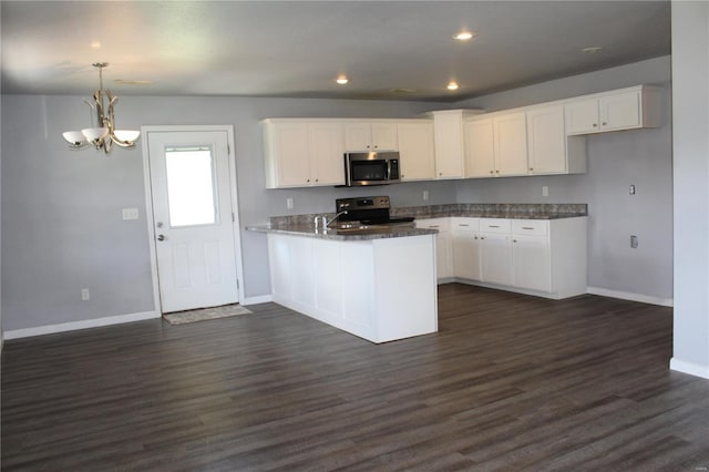 kitchen with a peninsula, baseboards, white cabinets, dark wood finished floors, and stainless steel appliances