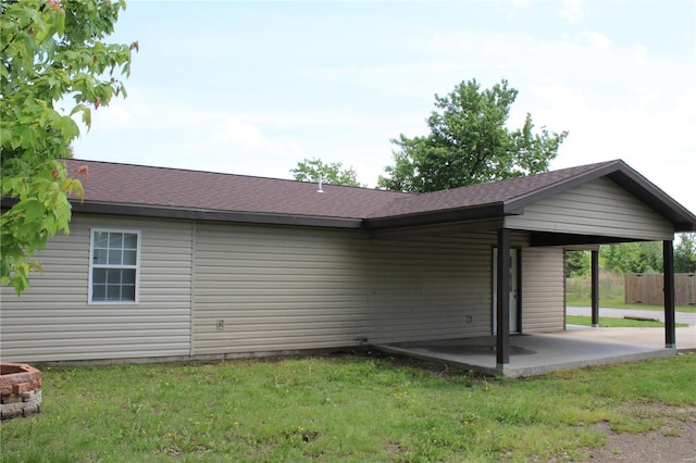 back of property featuring a lawn, fence, a shingled roof, and a patio area