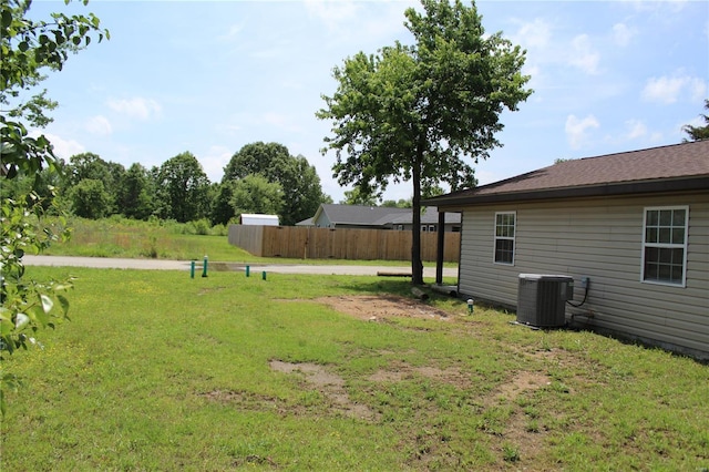 view of yard with fence and central AC unit