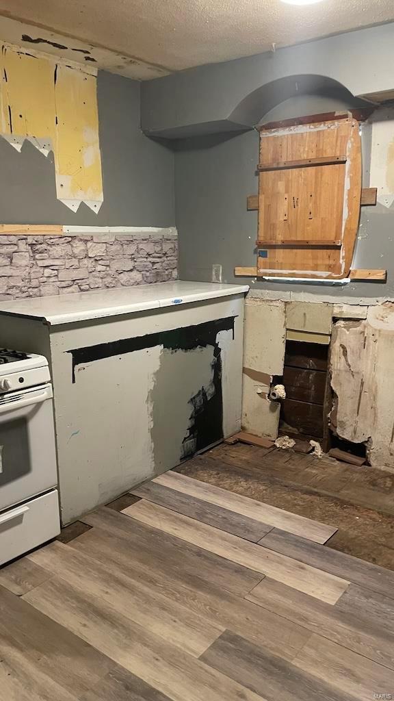 kitchen featuring light wood-style floors, light countertops, and white range with gas stovetop
