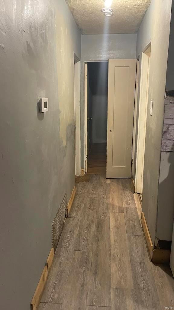 corridor with visible vents and wood finished floors