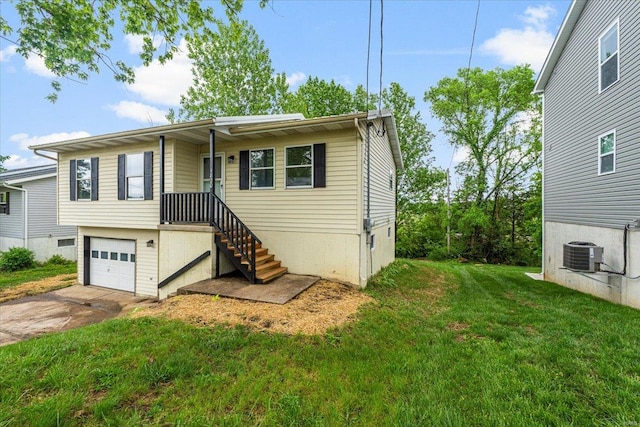 single story home with an attached garage, concrete driveway, a front yard, and cooling unit
