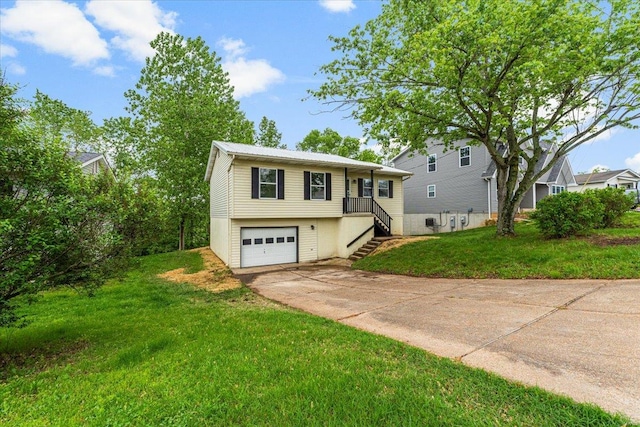 bi-level home with a garage, stairs, driveway, and a front lawn