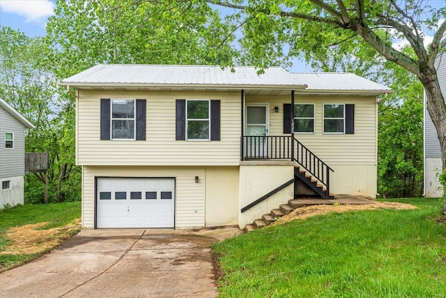 view of front facade with an attached garage, driveway, metal roof, and a front yard