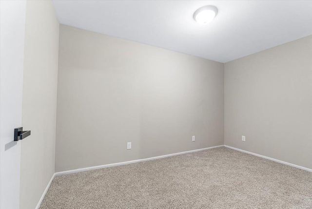 carpeted empty room featuring baseboards