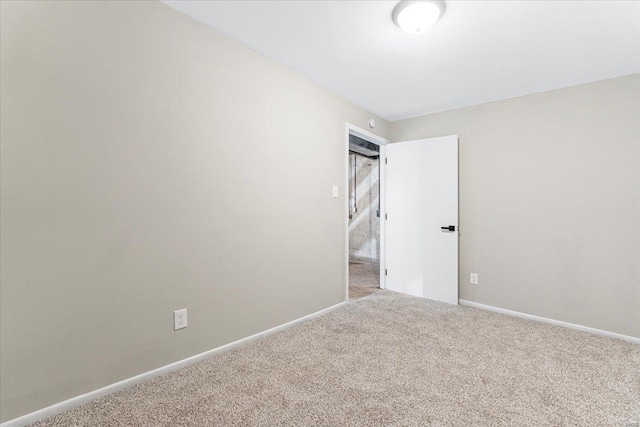 empty room featuring baseboards and carpet