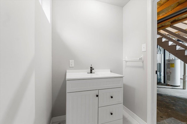bathroom featuring water heater, vanity, and baseboards