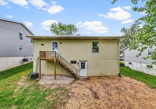 back of house featuring stairs, a yard, and central AC