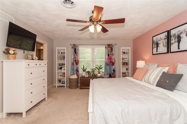 bedroom with ceiling fan, visible vents, light carpet, and baseboards