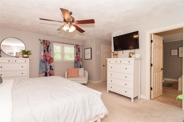 bedroom featuring visible vents, baseboards, ceiling fan, and light carpet