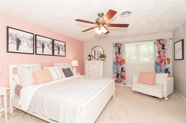 bedroom with baseboards, visible vents, light carpet, and ceiling fan