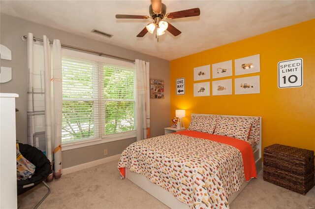 carpeted bedroom with baseboards, a ceiling fan, and visible vents