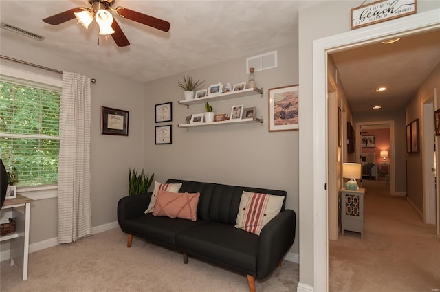 living area featuring carpet flooring, a ceiling fan, baseboards, and visible vents