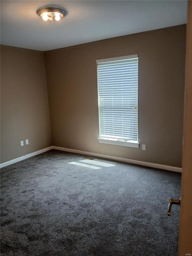 carpeted spare room with baseboards
