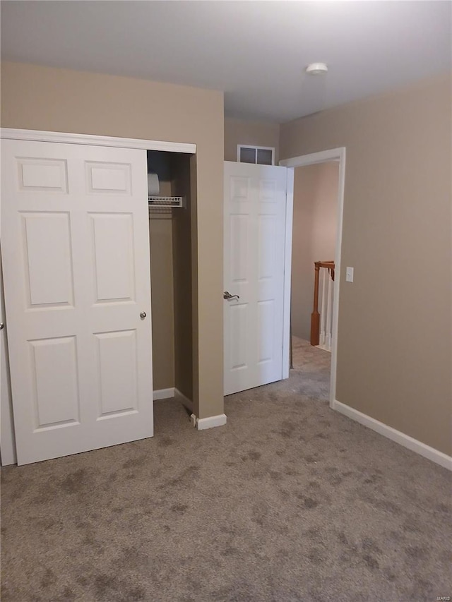 unfurnished bedroom with carpet flooring, baseboards, visible vents, and a closet