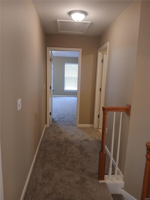 corridor with carpet flooring, baseboards, an upstairs landing, and attic access
