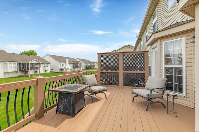 wooden terrace featuring a fire pit and a residential view
