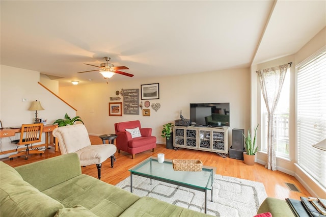 living area with baseboards, visible vents, and a wealth of natural light