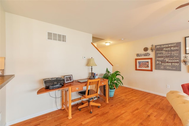 office space featuring visible vents, baseboards, ceiling fan, and wood finished floors