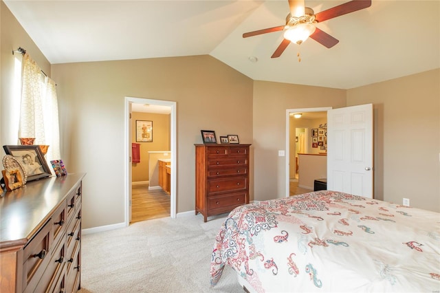 bedroom with connected bathroom, ceiling fan, light colored carpet, baseboards, and vaulted ceiling
