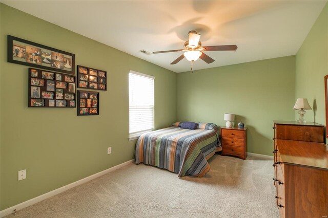 bedroom with carpet floors, baseboards, visible vents, and ceiling fan